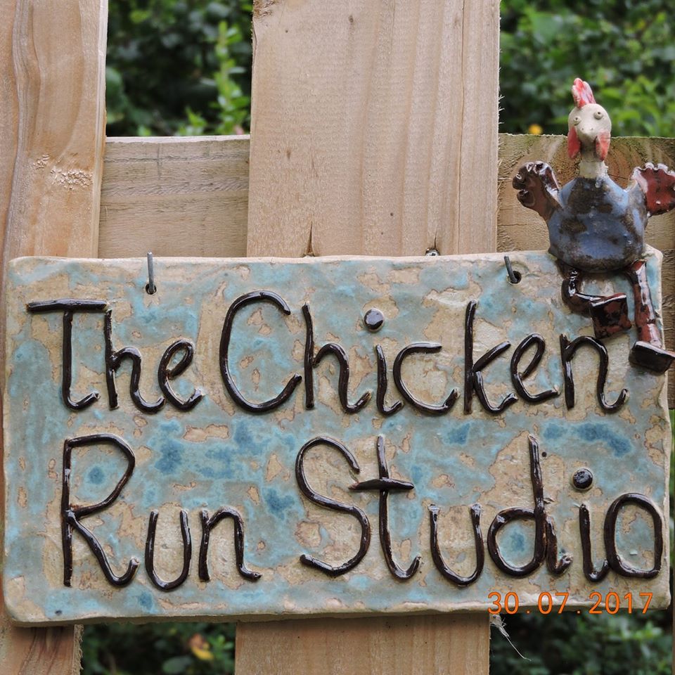 The Chicken Run Studio sign, made in stoneware, with a quirky chicken sitting on top.